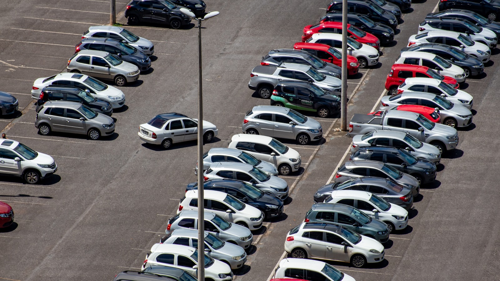 Parkplatz mit dicht stehenden Fahrzeugreihen von oben